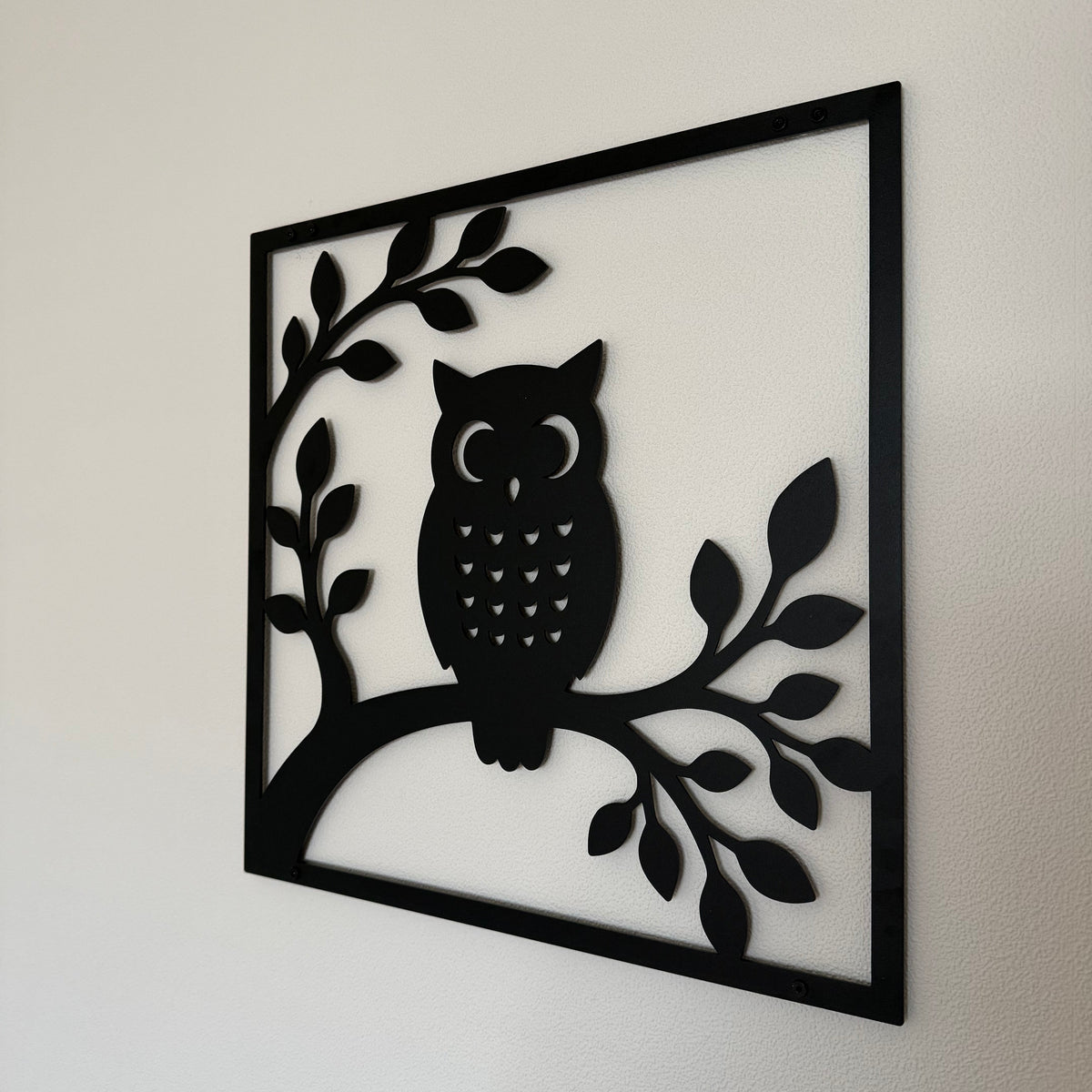Wanddecoratie OWL met uil gemonteerd aan een binnenmuur