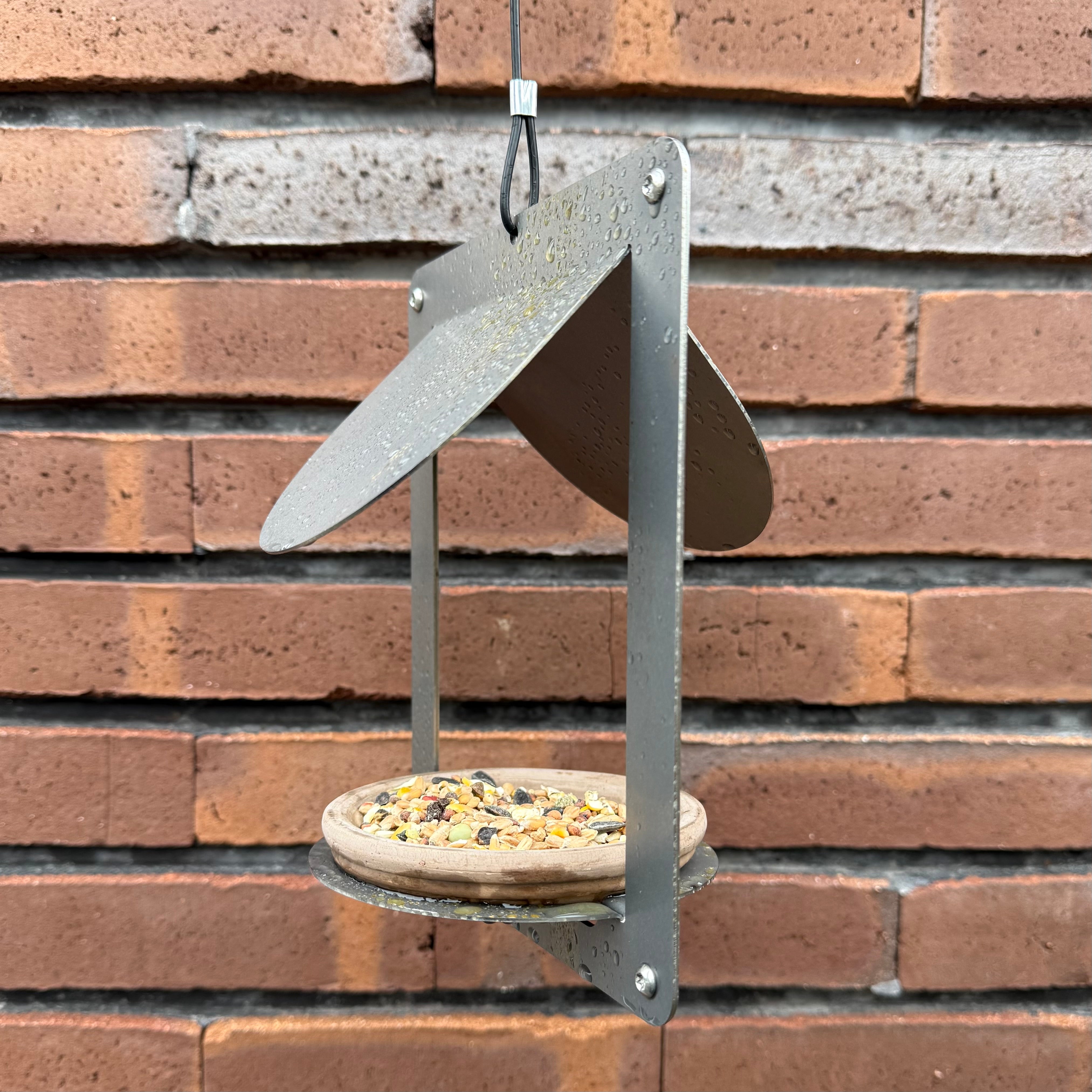 Design vogelvoederhuis WINGS van cortenstaal met terracotta schaaltje